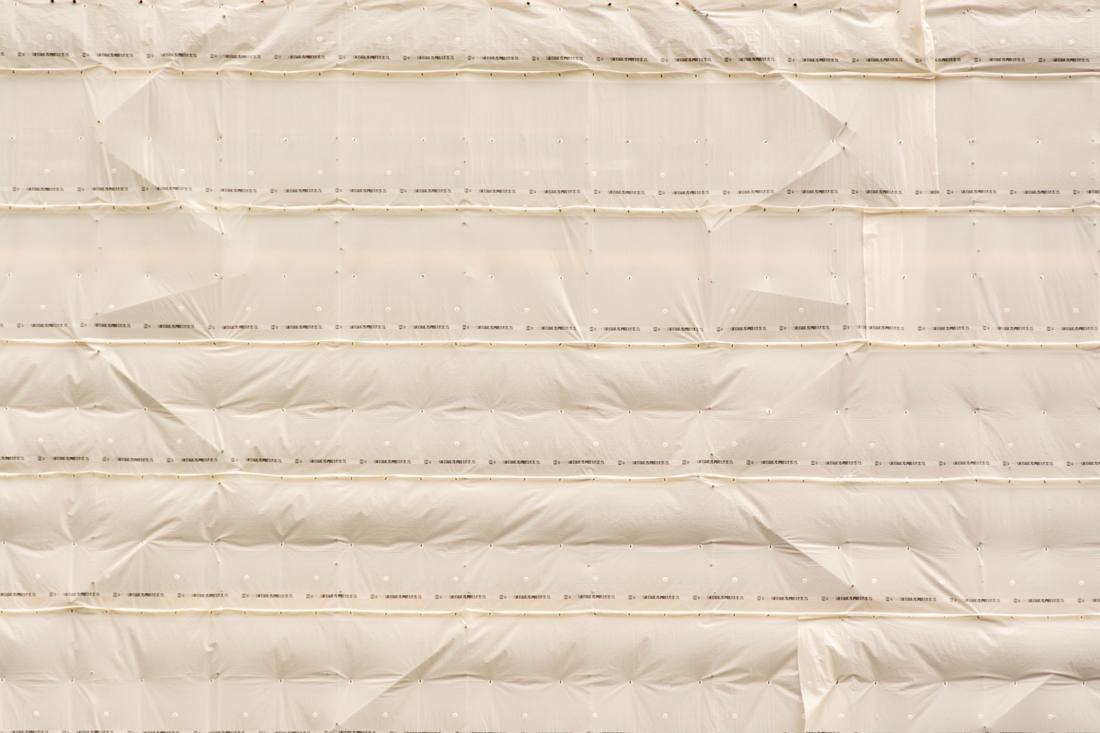 Textured beige cloth arrangement with pleats and folds, ideal for design backgrounds.